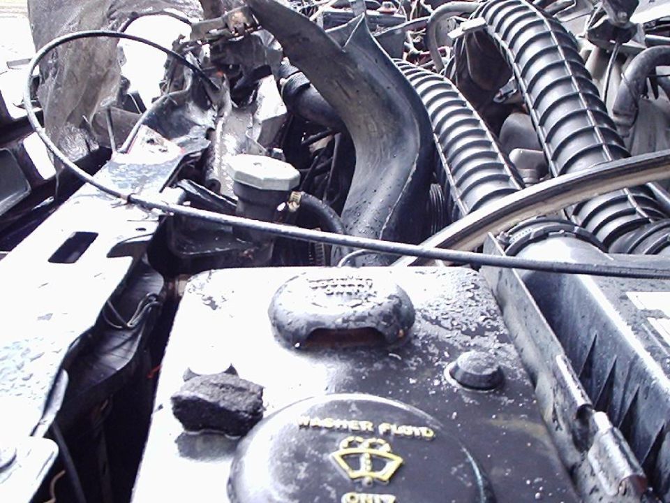 1995 Ford F-150 engine bay with visible washer fluid reservoir cap