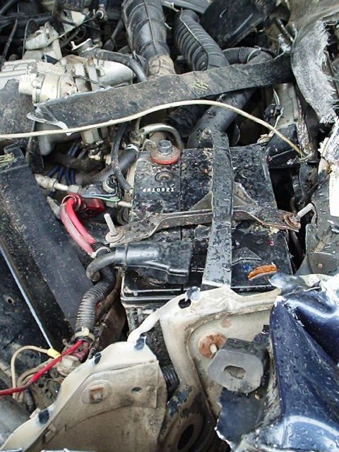 1995 Ford F-150 - Engine bay components are visible in this close-up photo, with a prominent car battery.