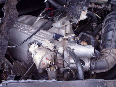 1995 Ford F-150 - The engine bay shows a complex arrangement of hoses, wires, and engine components, with some text visible on the intake manifold.
