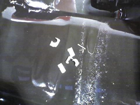 1991 Ford Mustang - Close-up of a car's interior floor showing debris and water, with a website logo visible.