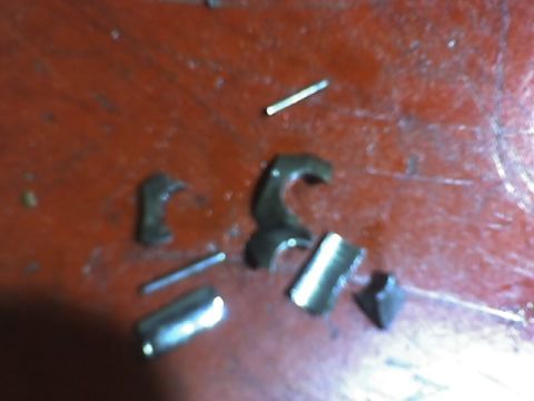 1991 Ford Mustang - Various metal components and pins are visible on a textured red background.