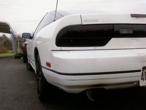 1991 Nissan 240SX - Rear view of a white 1991 Nissan 240SX coupe showing its distinctive taillights and Nissan badging.