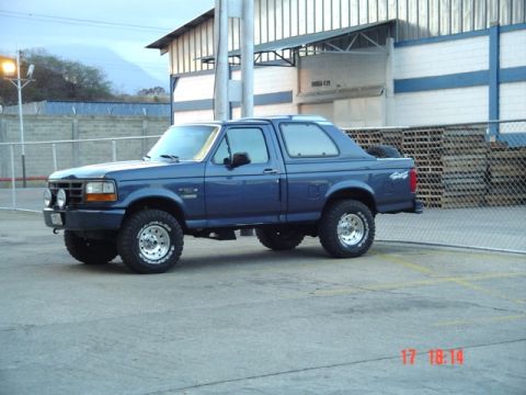1995 Ford F-150 - Blue 1995 Ford Bronco parked outside a building.