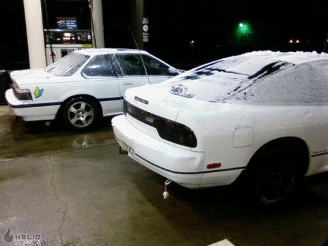 1991 Nissan 240SX - A white 1991 Nissan 240SX is parked next to another white car at a gas station in the snow.