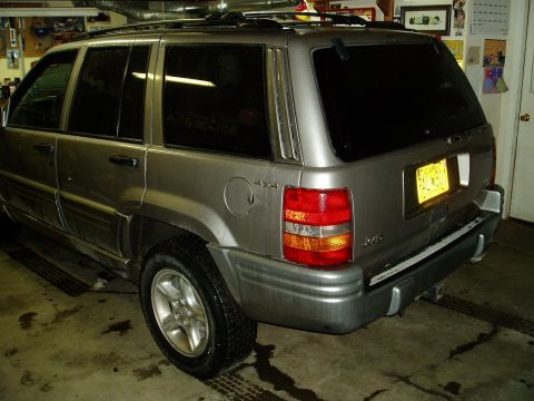 2000 Ford E350 - This Jeep Grand Cherokee is parked indoors, with its rear end visible and a trailer hitch attached.