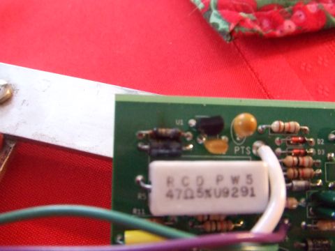 1995 Ford Mustang - Close-up of an electronic circuit board various components including resistors, capacitors, and a prominent white resistor with legible mar…