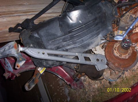 1995 Ford Bronco - A collection of assorted vehicle parts, including a brake rotor and hub, are piled together.
