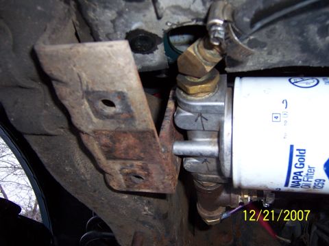1994 Ford Bronco - This is a close-up view of an oil filter and its mounting bracket, showing some rust on the bracket.