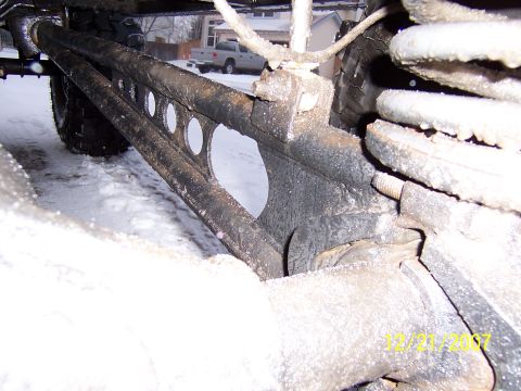 1994 Ford Bronco - A close-up view of vehicle suspension components in a snowy environment, with another vehicle visible in the background.