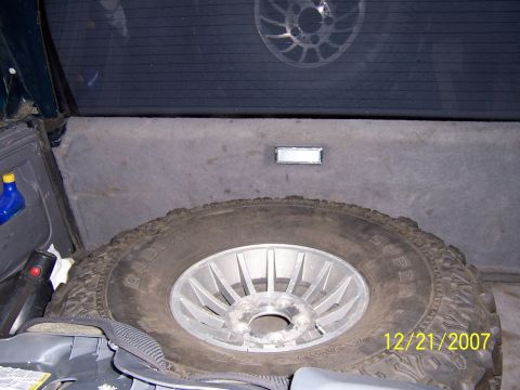 1994 Ford Bronco - The cargo area of the vehicle contains a spare tire, a blue bottle, and other items.
