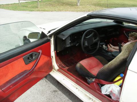 1995 Ford Probe - Interior of a car, showing the dashboard, seats, and a child sitting in the passenger seat.