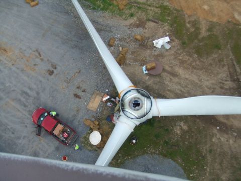 1996 Ford Bronco - Wind turbine rotor hub and blades with a red pickup truck on the ground below.