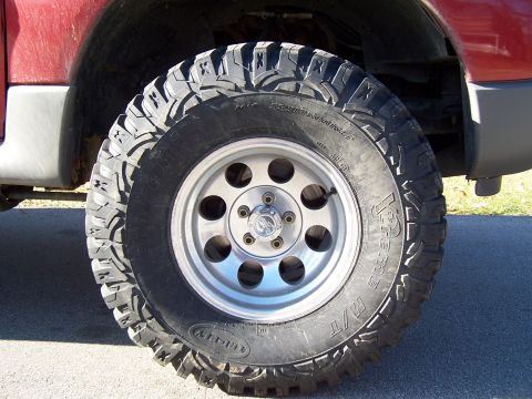 2002 Ford Sport Trac - Close-up of a tire and wheel on a red vehicle. The album claims it is a 2002 Ford Sport Trac.