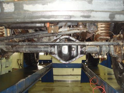 1996 Ford Bronco - Close-up view of the undercarriage, focusing on the differential and suspension system of a vehicle.