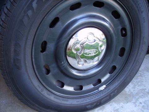 2005 Ford Crown Victoria - Chrome Ford hubcap on a black steel wheel, with Goodyear tire visible.
