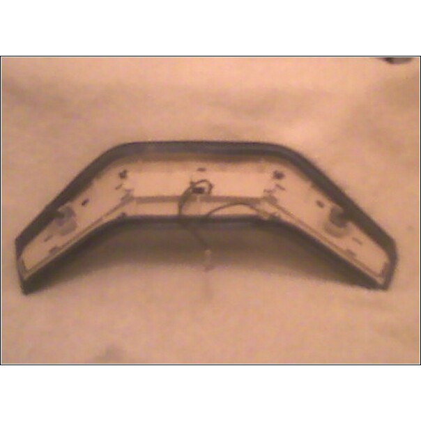 Underside of a dark-trimmed car part with wiring and mounting points visible