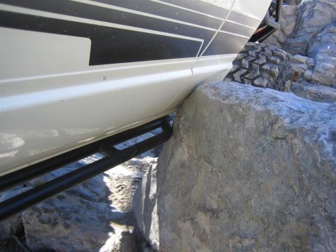 1987 Suzuki Samurai - Off-road vehicle with rock sliders maneuvering over large boulders.