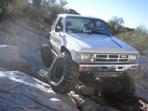 1987 Suzuki Samurai - A modified Toyota pickup truck navigates a rocky, off-road trail.
