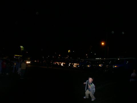 2007 Toyota FJ Cruiser - A boy poses in the foreground as a line of vehicles is visible in the background at night.