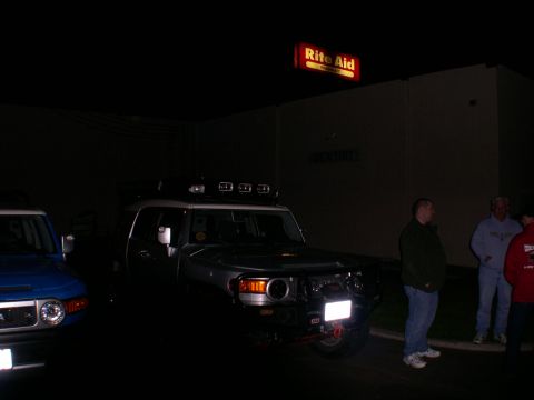 2007 Toyota FJ Cruiser - Two Toyota FJ Cruisers are parked outside a Rite Aid pharmacy at night.
