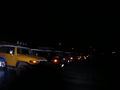 2007 Toyota FJ Cruiser - A line of Toyota FJ Cruisers are parked at night, with the yellow one in the foreground.