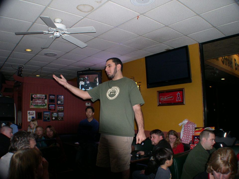 People gathered in a bar or restaurant with a man speaking