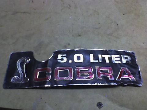 1991 Ford Mustang - A 1991 Ford Mustang Cobra 5.0 Liter engine bay emblem is shown.