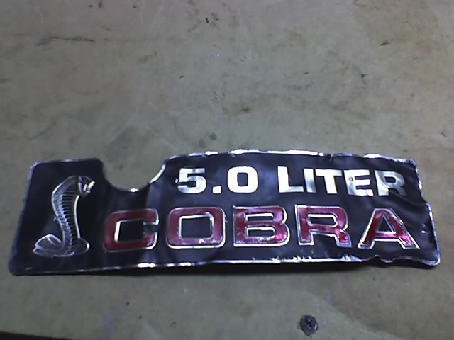 Black 5.0 Liter Cobra emblem with a coiled snake logo and red lettering