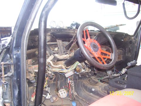 1978 Ford Bronco - The interior of a vehicle shows extensive exposed wiring and a custom steering wheel, suggesting a project in progress.