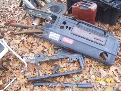 1978 Ford Bronco - Various vehicle dashboard components and a red jerry can are scattered amongst fallen autumn leaves.