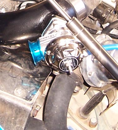1988 Pontiac Fiero - A close-up view of a chrome blow-off valve, a component of a vehicle's engine system.