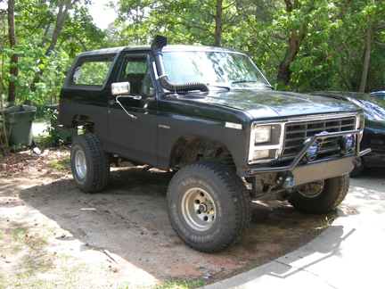 1985 Ford Bronco - This modified Ford Bronco features a snorkel and custom front bumper, suggesting off-road use.
