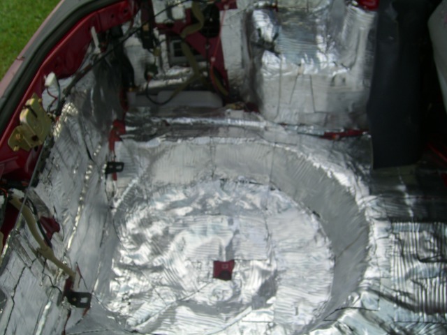 Car interior with silver sound deadening material applied to the floor and wheel wells