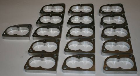 1993 Ford Taurus - A collection of throttle body spacers is displayed, ready for installation.