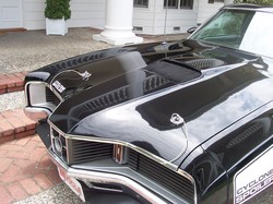 1972 Ford Ranchero - A black 1972 Ford Ranchero is shown from the front, highlighting its distinctive hood scoop and side text.