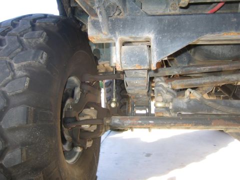 1994 Ford Bronco - Front suspension and tire detail of an off-road vehicle, showing leaf springs and steering linkage.