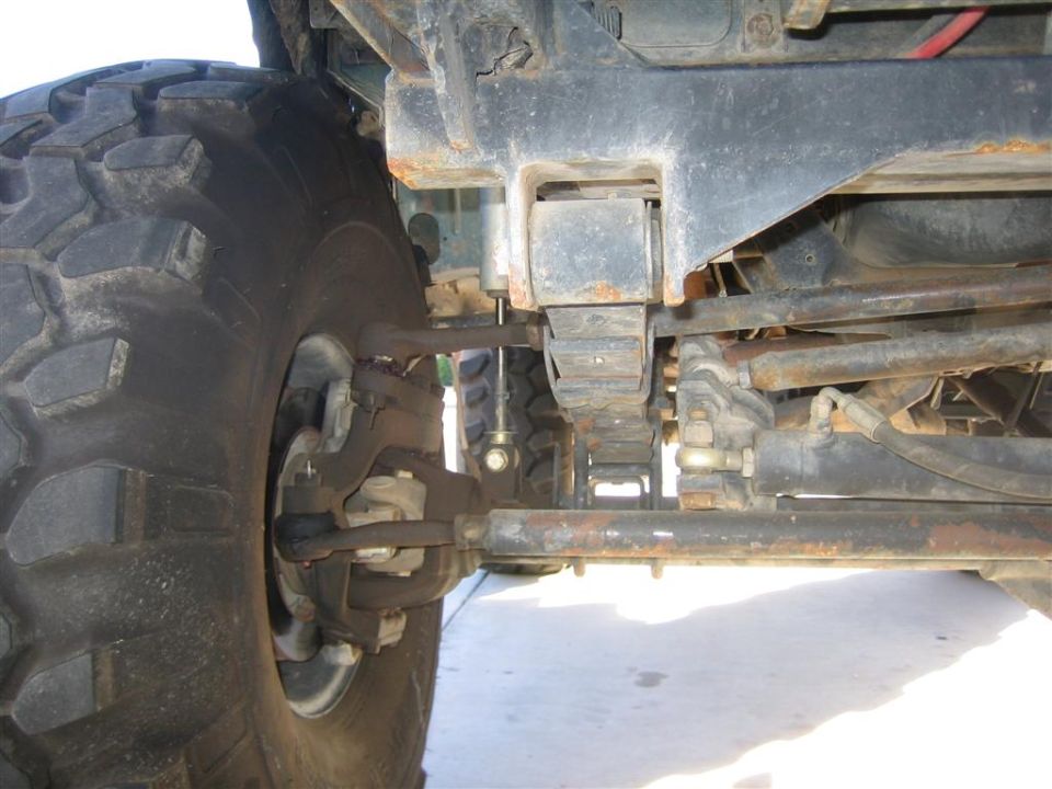 Close-up of a large off-road tire and suspension components, likely from a truck or SUV
