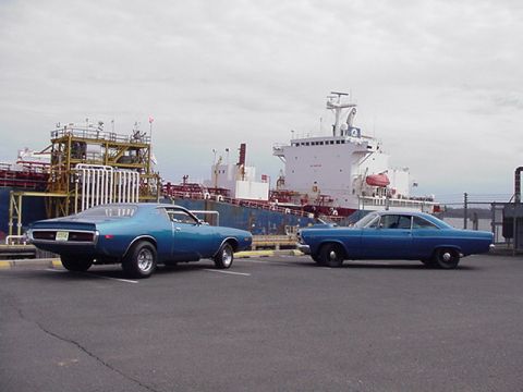 1966 Ford Fairlane - A 1971 Dodge Charger and a 1966 Ford Fairlane are parked near a large cargo ship.