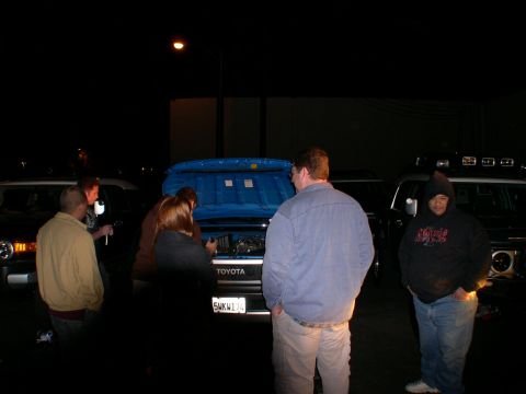 2007 Toyota FJ Cruiser - People examine the engine of a 2007 Toyota FJ Cruiser at night.