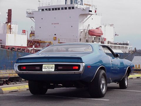 1966 Ford Fairlane - Rear view of a blue 1971 Dodge Charger parked near a large ship at a dock.