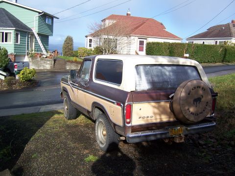 1978 Ford Bronco - Rear view of a 1978 Ford Bronco with a spare tire cover, parked in a driveway.