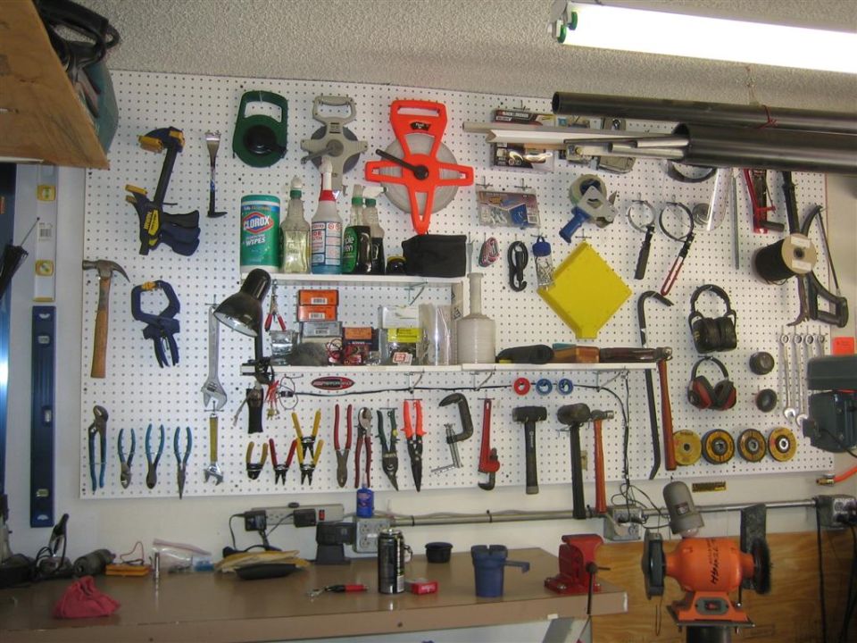 Workbench with tools, including hammers, wrenches, and pliers, organized on a pegboard