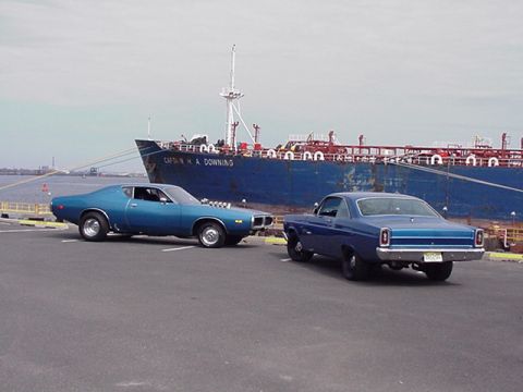 1966 Ford Fairlane - A 1971 Dodge Charger and a 1966 Ford Fairlane are parked side-by-side with a large ship behind them.