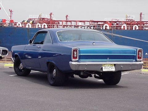 1966 Ford Fairlane - Rear view of a blue 1966 Ford Fairlane coupe parked near a large ship.