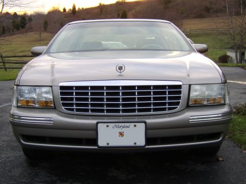 1996 Mercury Grand Marquis - This tan Cadillac features a prominent chrome grille and a Maryland license plate, seen from the front.