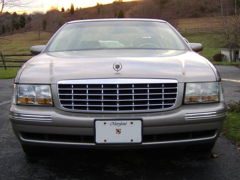 Gold luxury sedan, head-on front view with chrome grille and Maryland plate