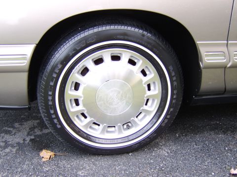 1996 Mercury Grand Marquis - A close-up view of a vehicle's wheel and fender, showing the tire and wheel details.