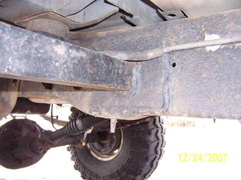 1994 Ford Bronco - A close-up view of the undercarriage reveals the vehicle's frame, suspension components, and a portion of the tire, with a visible date sta…