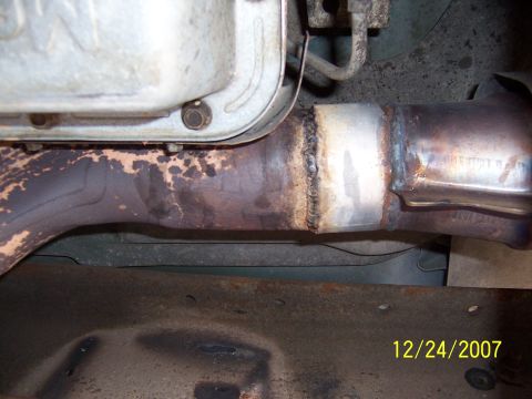 1994 Ford Bronco - Close-up of a welded exhaust pipe section, showing repair work on a vehicle's undercarriage.