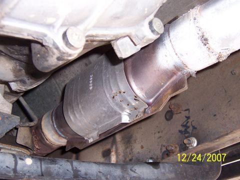1994 Ford Bronco - A close-up view of a vehicle's catalytic converter and exhaust pipe system.